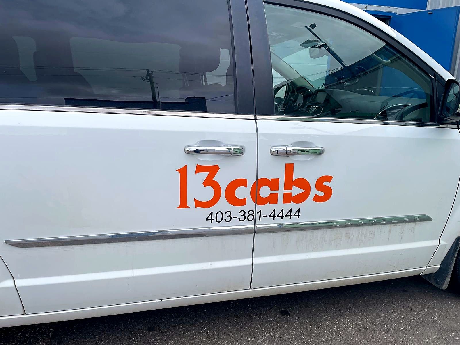 13cabs logo and phone number on the side door of a white van