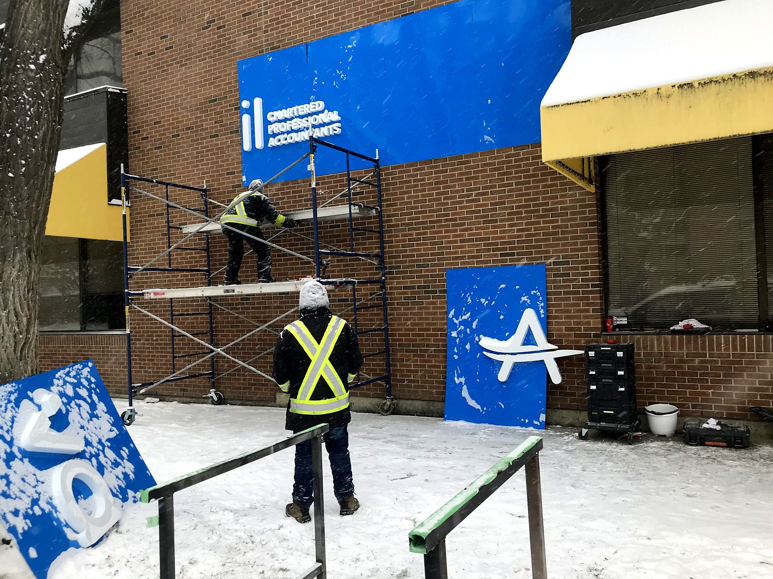 Installers on scaffolding mounting the Avail fascia panels in winter