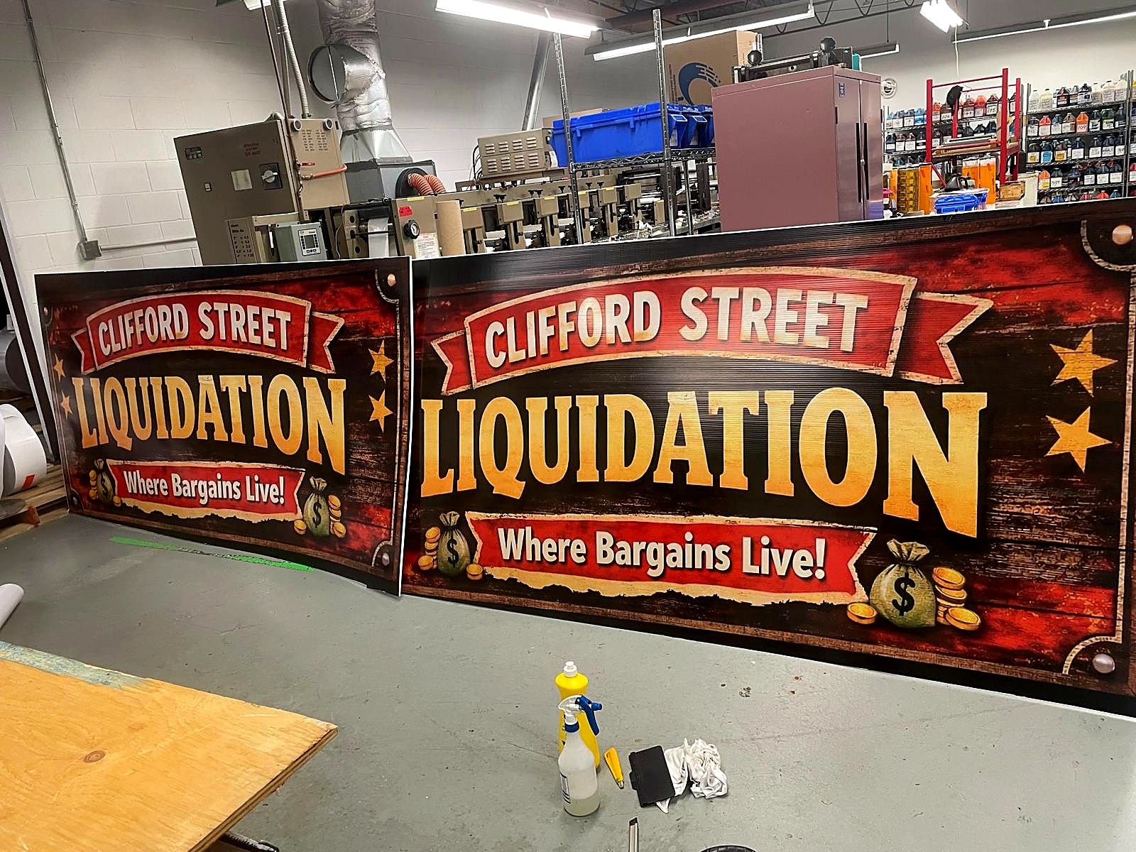 Two Clifford Street Liquidation banners in red and gold