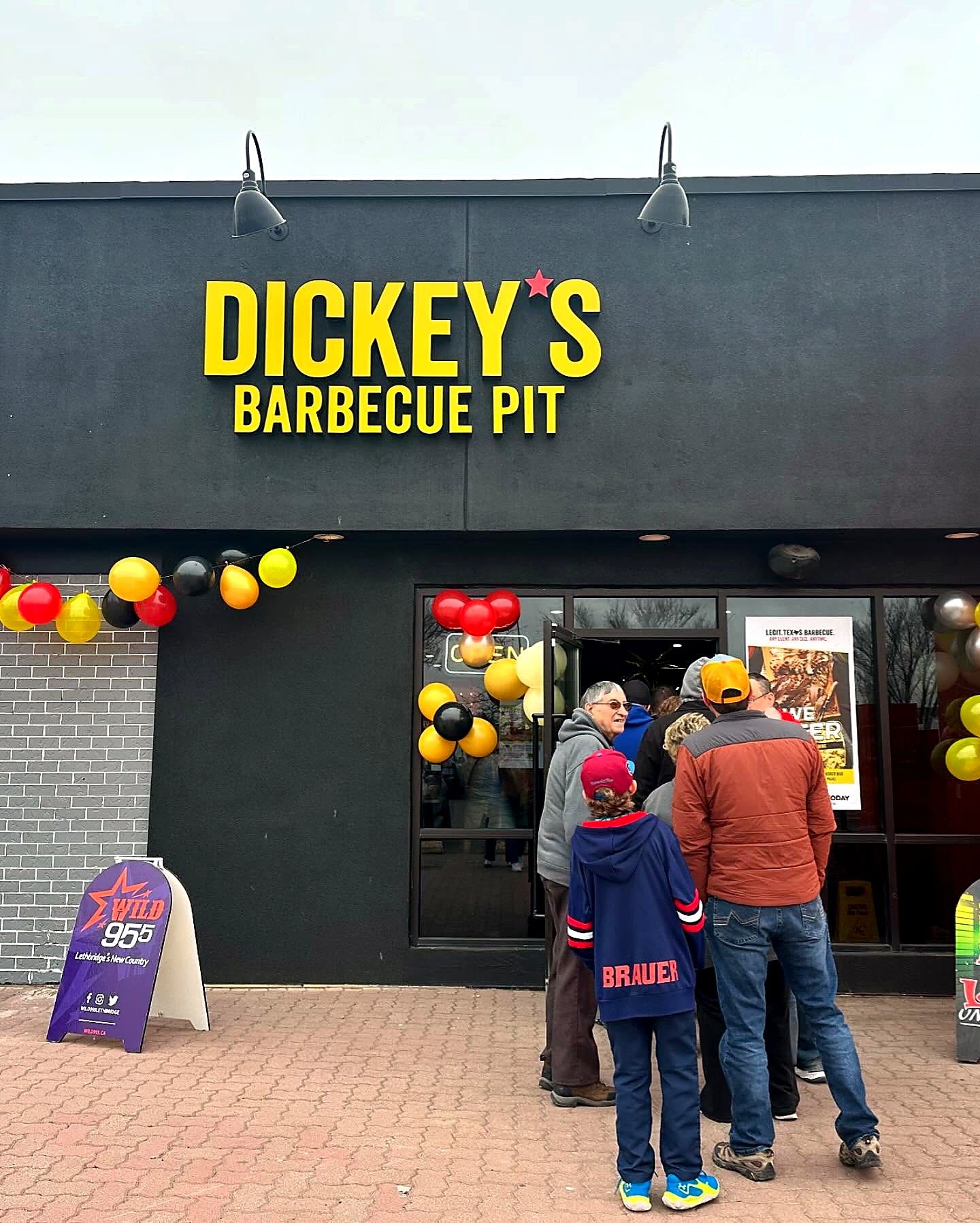 Dickey's Barbecue Pit yellow lettering on a black storefront on opening day
