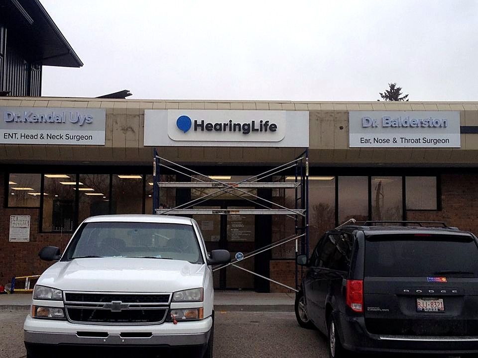 Scaffolding in front of HearingLife and medical office storefronts during sign installation